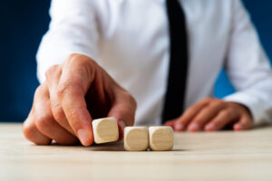 businessman placing three blank wooden dices in a row