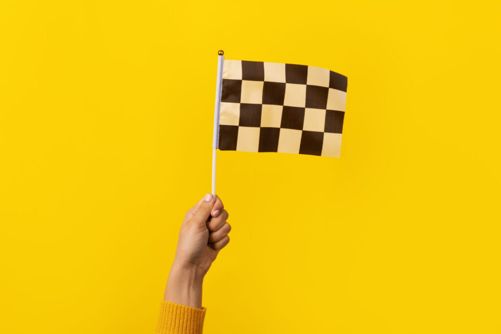 checkered flag in hand over yellow background